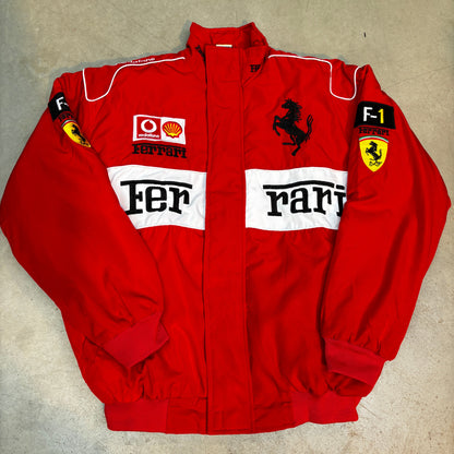 Folded red ferrari racing suit with visible branding on a beige surface